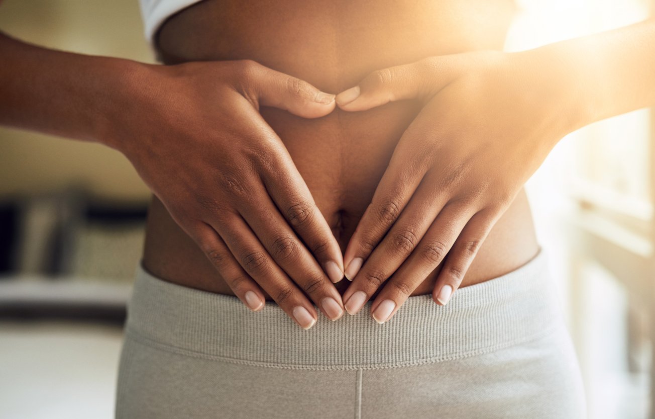 Hands of Woman on Stomach, Diet and Fitness for Gut Health and Lipo Wellness for Body Positivity. Gym, Healthcare and Tummy Tuck, Girl Model with Heart Hand Sign on Abdomen for Muscle Exercise Goals.